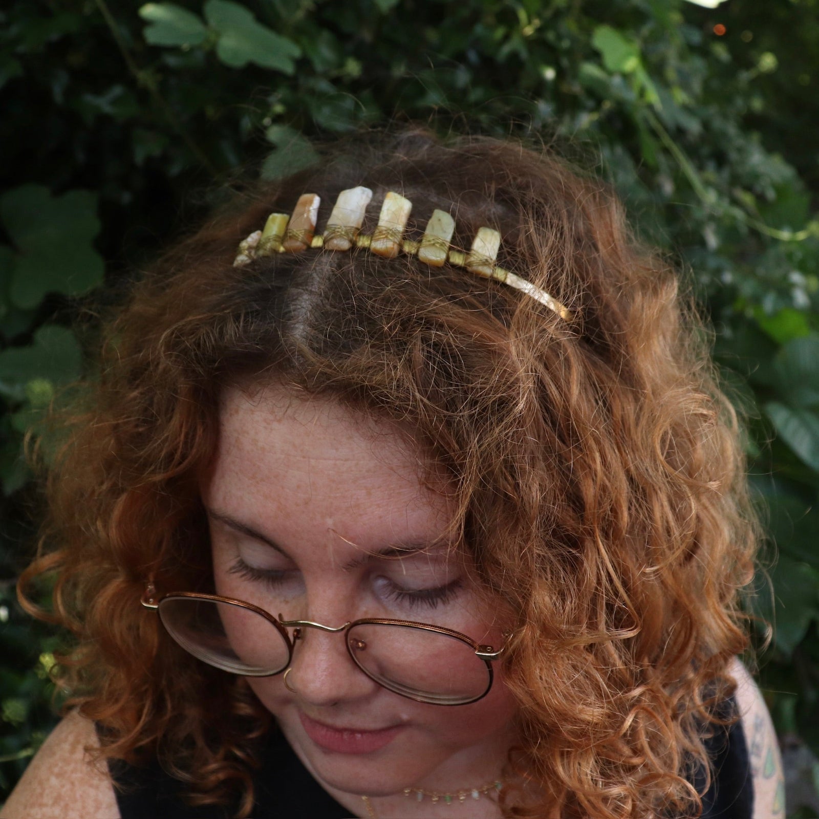 A woman wearing the Fairy Crown / Celtic Tiara - Peruvian Yellow Opal in front of greenery.