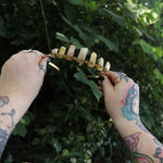 Someone holding the Fairy Crown / Celtic Tiara - Peruvian Yellow Opal in front of greenery.