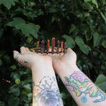 Someone holding the Fairy Crown / Celtic Tiara - Sea Urchin Spines II in front of greenery.