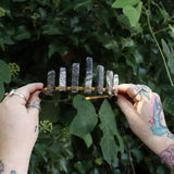 Someone holding the Fairy Crown / Celtic Tiara - Black Line Jasper - Spiderweb in front of greenery.