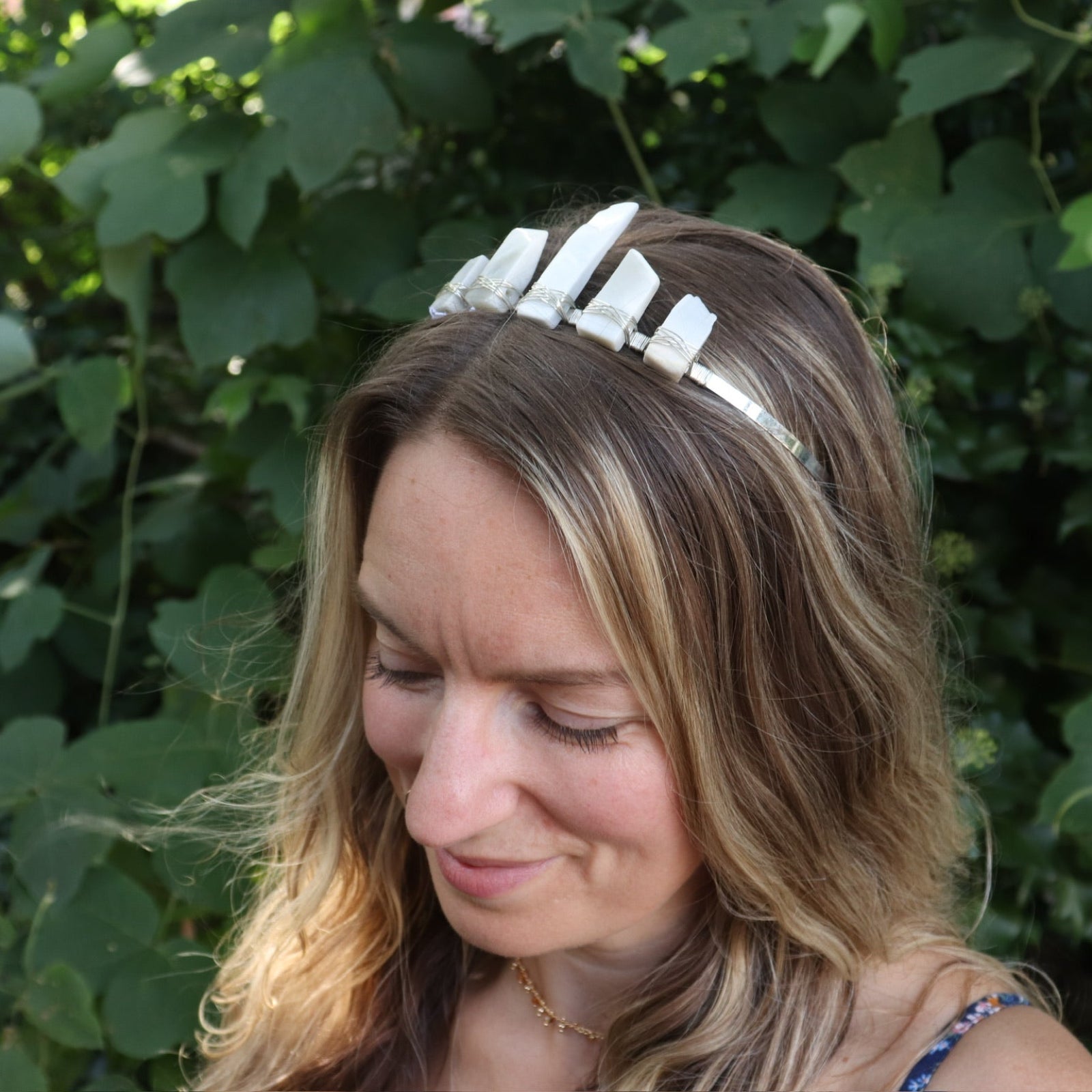 A woman wearing the Fairy Crown / Celtic Tiara - Moonstone - Ice Queen in front of greenery.