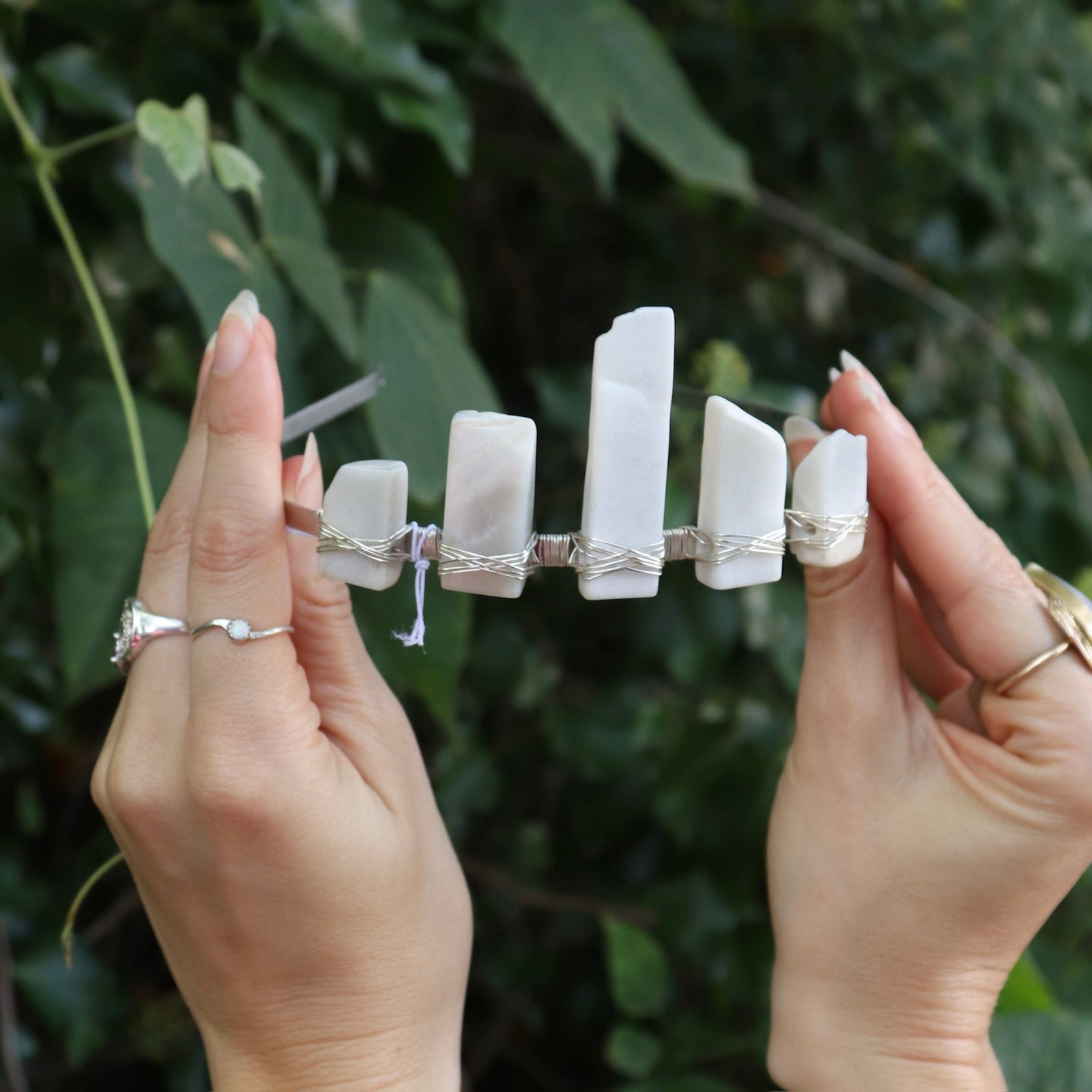 Someone holding the Fairy Crown / Celtic Tiara - Moonstone - Ice Queen in front of greenery.