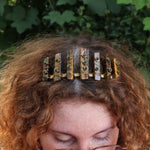 A woman wearing the Tigers Eye & Malachite Tiara in front of greenery.
