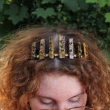 A woman wearing the Tigers Eye & Malachite Tiara in front of greenery.