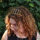 A woman wearing the Tigers Eye & Malachite Tiara in front of greenery.