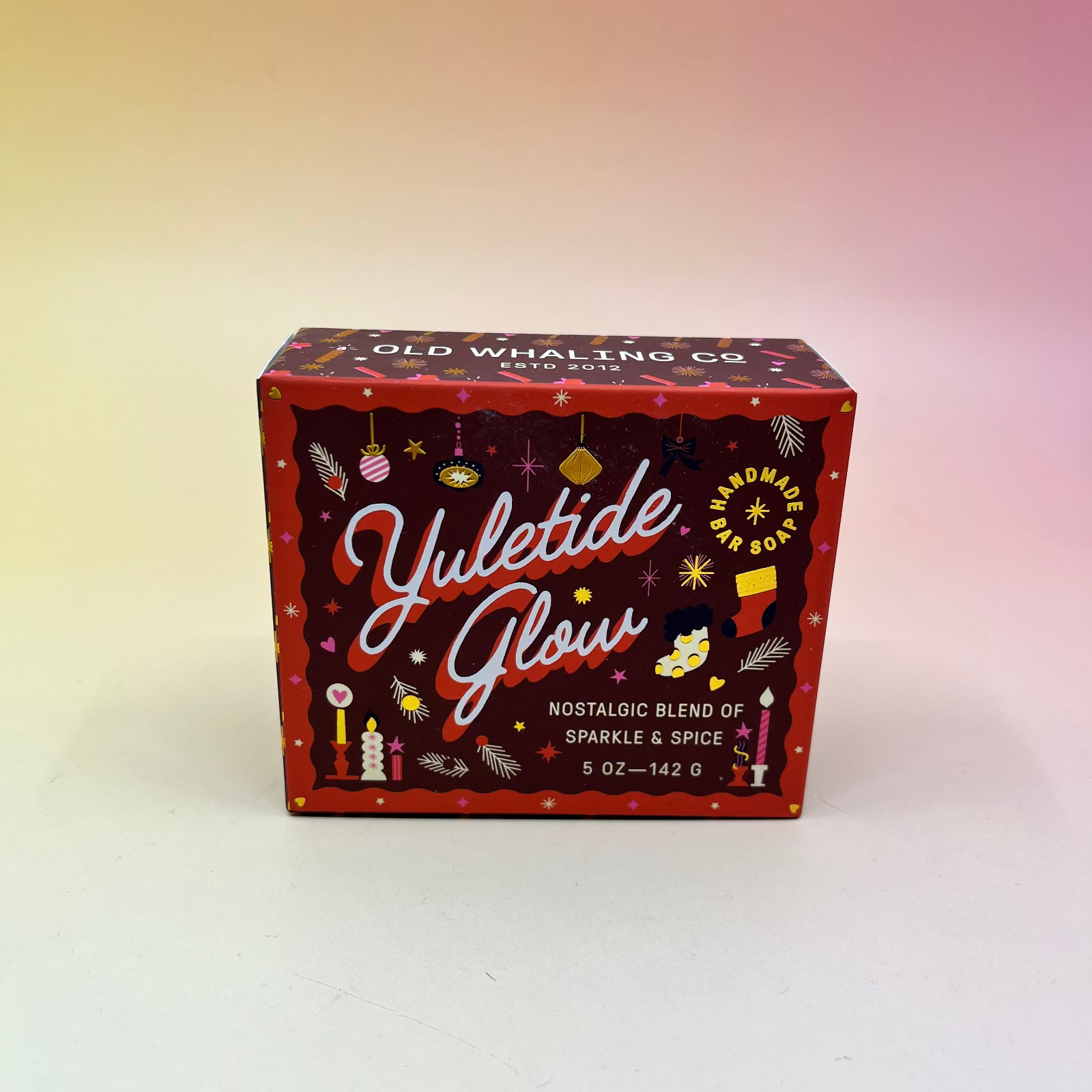 The Yuletide Glow Holiday Bar Soap in front of a pink and yellow background.