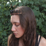 A woman wearing the Fairy Crown / Celtic Tiara - Smoky Quartz in front of greenery.