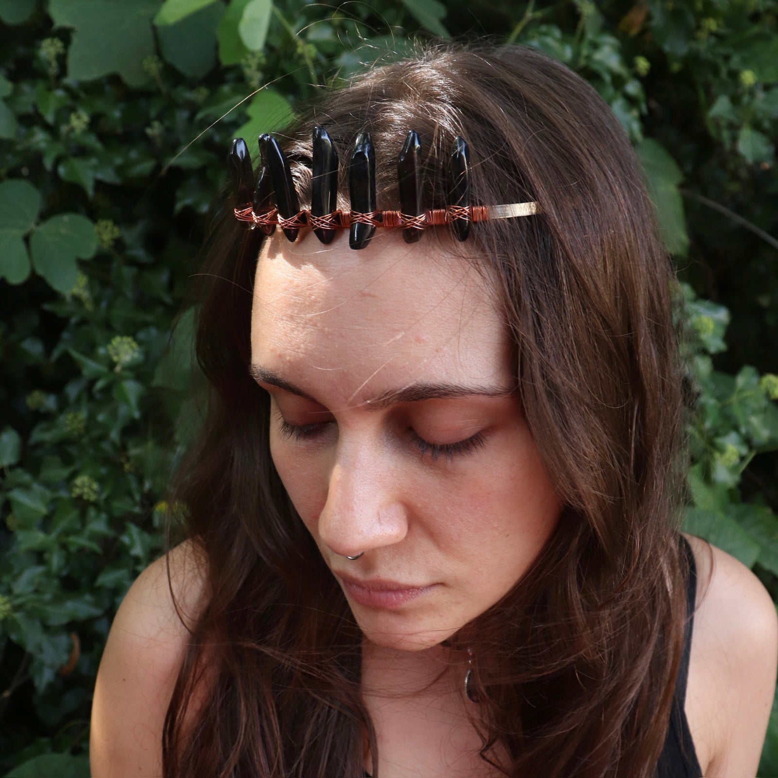A woman wearing the Fairy Crown / Celtic Tiara - Smoky Quartz in front of greenery.