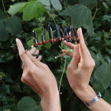 Someone holding the Fairy Crown / Celtic Tiara - Smoky Quartz in front of greenery.
