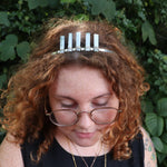 A woman wearing the Fairy Crown / Celtic Tiara - Oregon Blue Opal in front of greenery.