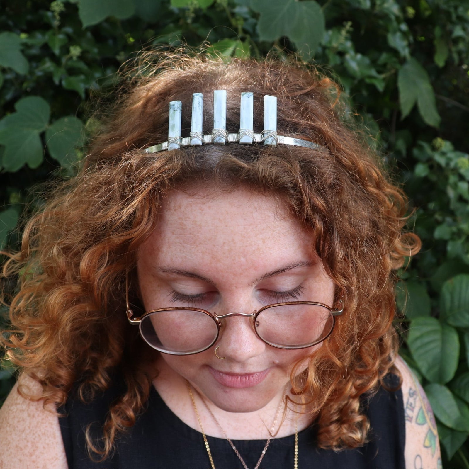A woman wearing the Fairy Crown / Celtic Tiara - Oregon Blue Opal in front of greenery.
