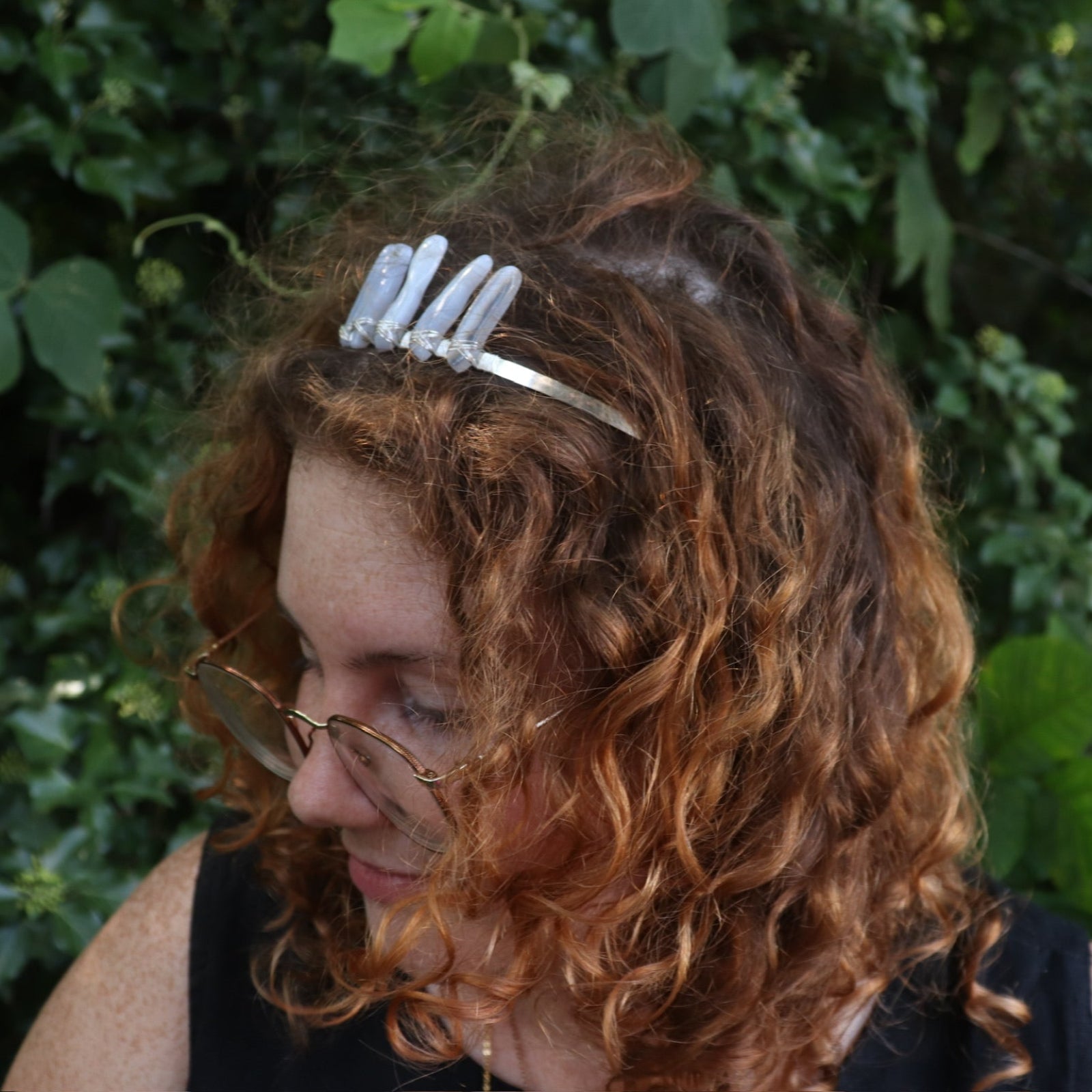 A woman wearing the Fairy Crown / Celtic Tiara - Blue Chalcedony in front of greenery.