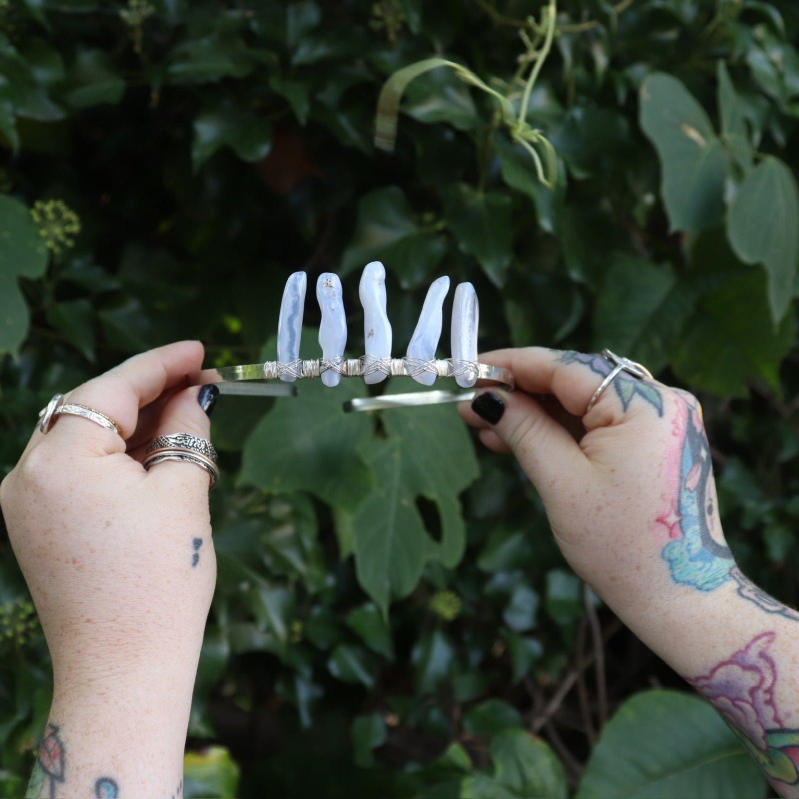 Someone holding the Fairy Crown / Celtic Tiara - Blue Chalcedony in front of greenery.