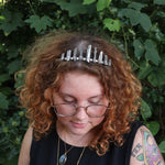 A woman wearing the Fairy Crown / Celtic Tiara - Titanium Quartz in front of greenery.