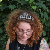 A woman wearing the Fairy Crown / Celtic Tiara - Titanium Quartz in front of greenery.