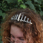 A woman wearing the Fairy Crown / Celtic Tiara - Titanium Quartz in front of greenery.