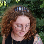 A woman wearing the Fairy Crown / Celtic Tiara - Orange & Blue Sodalite in front of greenery.