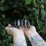 Someone holding the Fairy Crown / Celtic Tiara - Orange & Blue Sodalite in front of greenery.
