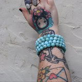 Someone wearing three of the large Natural Larimar Bracelet – 7.5” Stretch Fit.