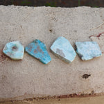 Some Natural Larimar Crystal Slabs on a cement background.