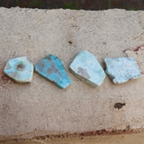 Some Natural Larimar Crystal Slabs on a cement background.