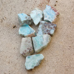 Multiple Natural Larimar Small Crystal Slabs on a cement background.