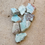 Multiple Natural Larimar Small Crystal Slabs on a cement background.