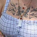 A woman wearing the Selenite Carnelian Gold Adjustable Necklace with a blue top.