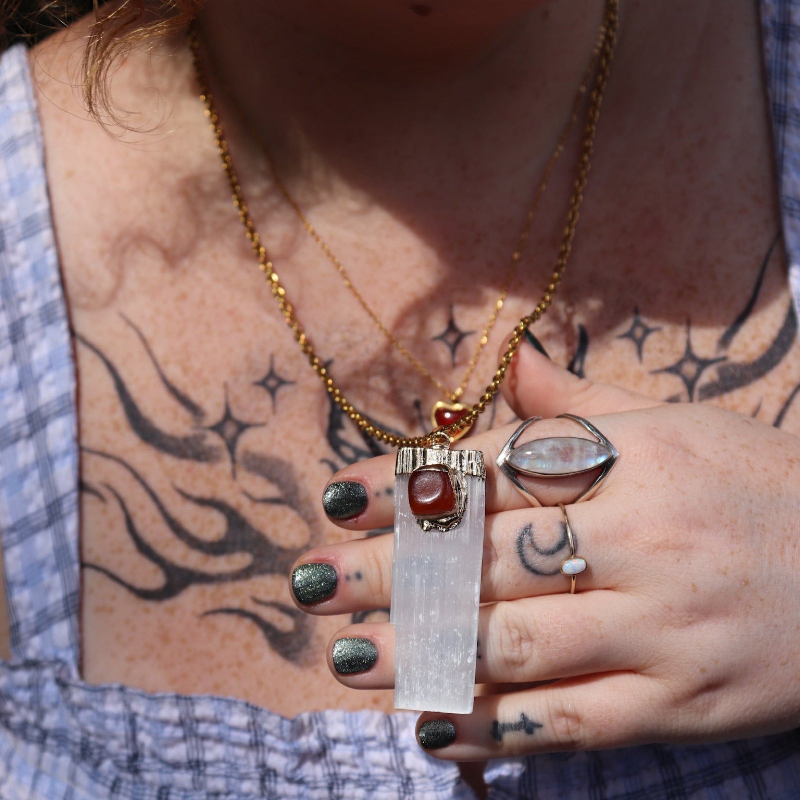 A woman wearing the Selenite Carnelian Gold Adjustable Necklace with a blue top.