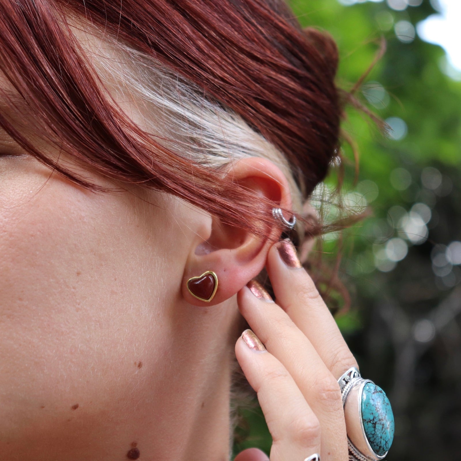 A woman wearing the gold earrings from the Carnelian Earrings & Necklace Gift Jewelry Set.