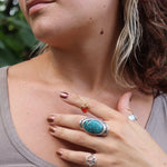 A woman wearing the gold necklace from the Carnelian Earrings & Necklace Gift Jewelry Set.