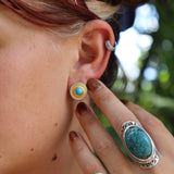 Someone wearing the Turquoise Gold Stud Earrings.