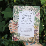 Someone holding the Green Witch's Garden Journal by Arin Murphy-Hiscock in front of greenery.