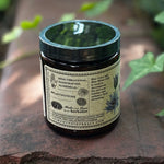 The side of the Blue Lotus Flower of Intuition Powder on a rusty red surface surrounded by ivy.