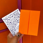 Someone holding the Outer Space I Love You Letterpress Greeting Card in front of an orange and pink wall.