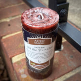 The Astro Magic Saturn - Get the F* Out Candle sitting on a brick.