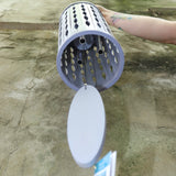 An up-close image of someone holding the Lavender Mist Bamboo Aloha Wind Chime in front of a concrete wall.