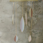 Someone holding the Mellow Stained Glass Suncatcher in front of a cement wall.
