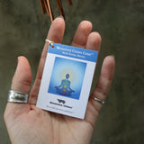 Someone holding the tag of the Seven Stones Bronze Woodstock Chakra Chime in front of a concrete wall.