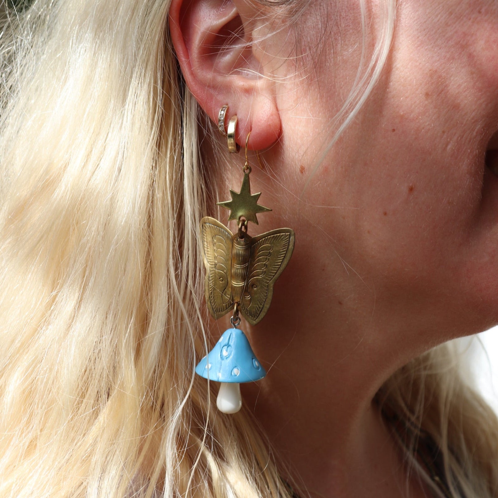 A woman wearing the blue Garden Goddess Mushroom Earrings.