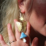 A woman wearing the blue Garden Goddess Mushroom Earrings.