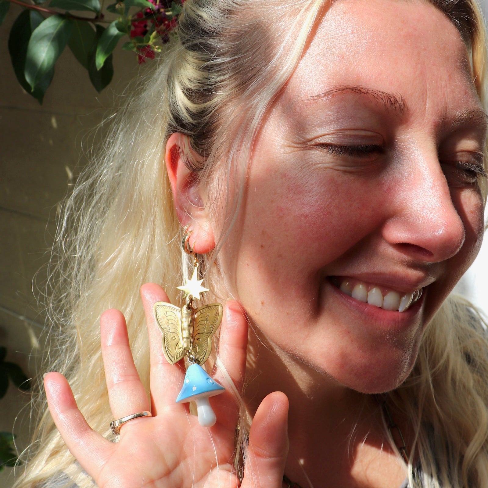 A woman wearing the blue Garden Goddess Mushroom Earrings.