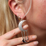 A woman wearing the Silver Many Moons 2.5 inch. Earrings.