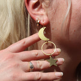 Someone wearing the Brass Rhiannon Moon and Star 3 inch. Earrings.