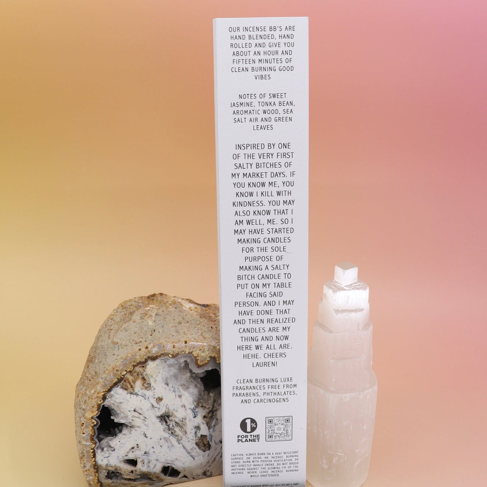 The back of the Bohemian Rêves - Salty Bitch Bye Hand Rolled Botanical Incense Sticks in front of an open geode and a selenite tower all on a pink and yellow background.