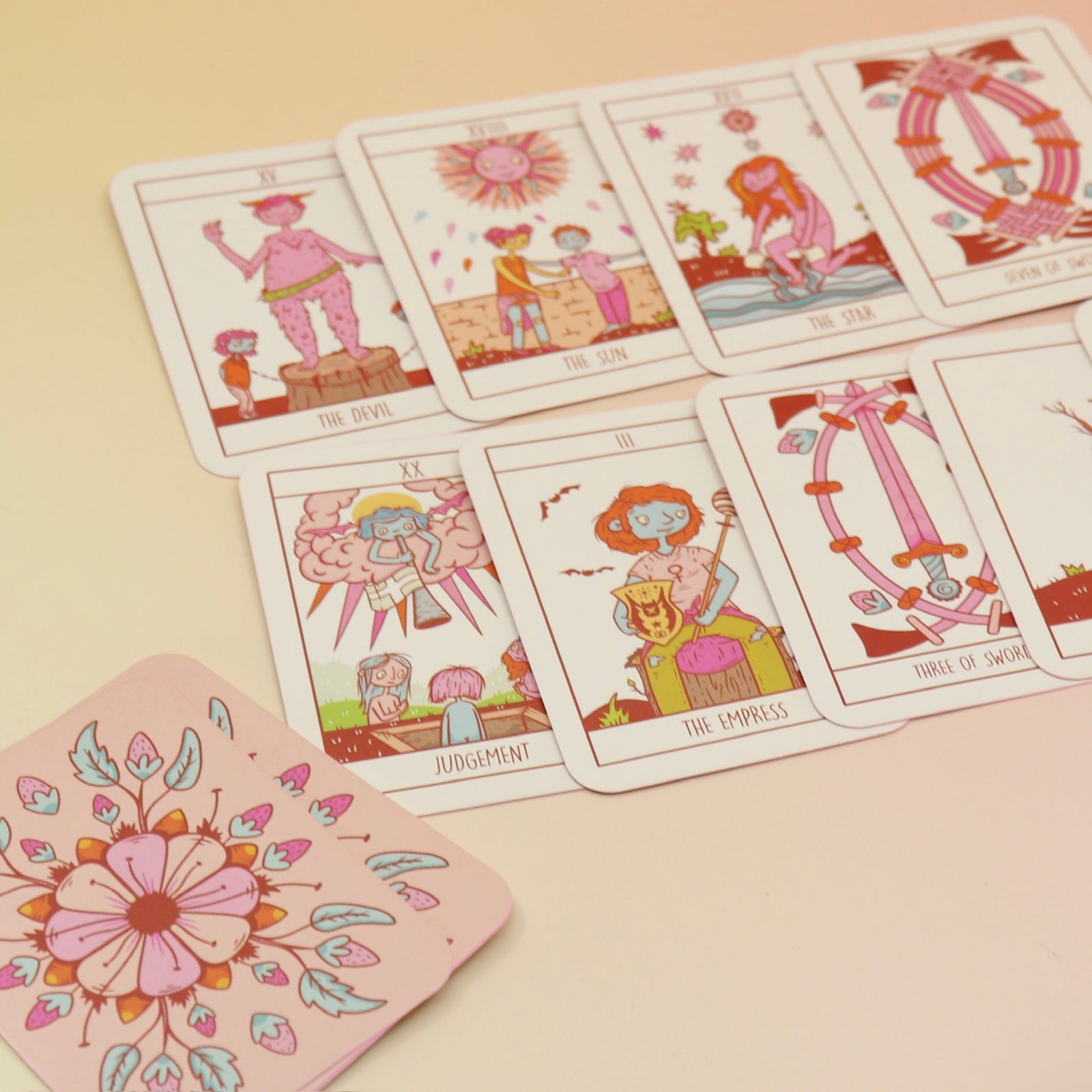 The contents of the Squid Cake Marseille Tarot Deck all on a pink and yellow background.
