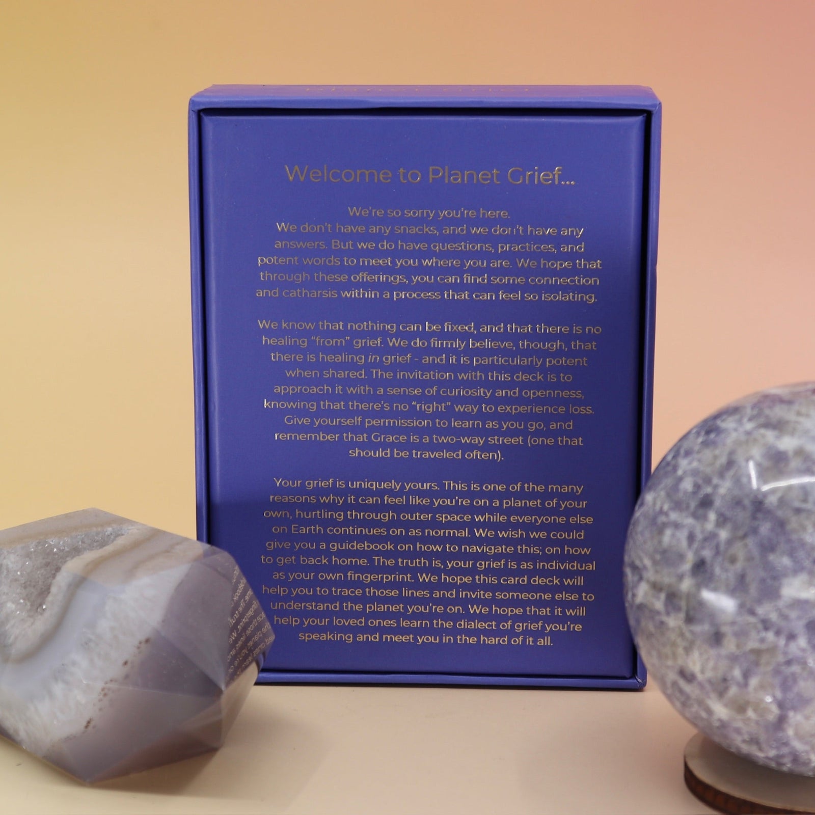 The Planet Grief Card Deck Bereavement Resource on a pink and yellow background, showing off the back.