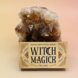 The Witch Magick Affirmation + Divination Cards against a citrine piece all on a pink and yellow background.