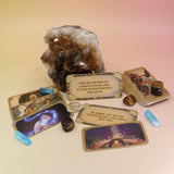 The contents of the Magical Messages from the Universe Affirmation + Divination Cards leaning against a citrine piece all on a pink and yellow background.