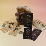 The Witch Magick Affirmation + Divination Cards against a citrine piece and all over on a pink and yellow background.
